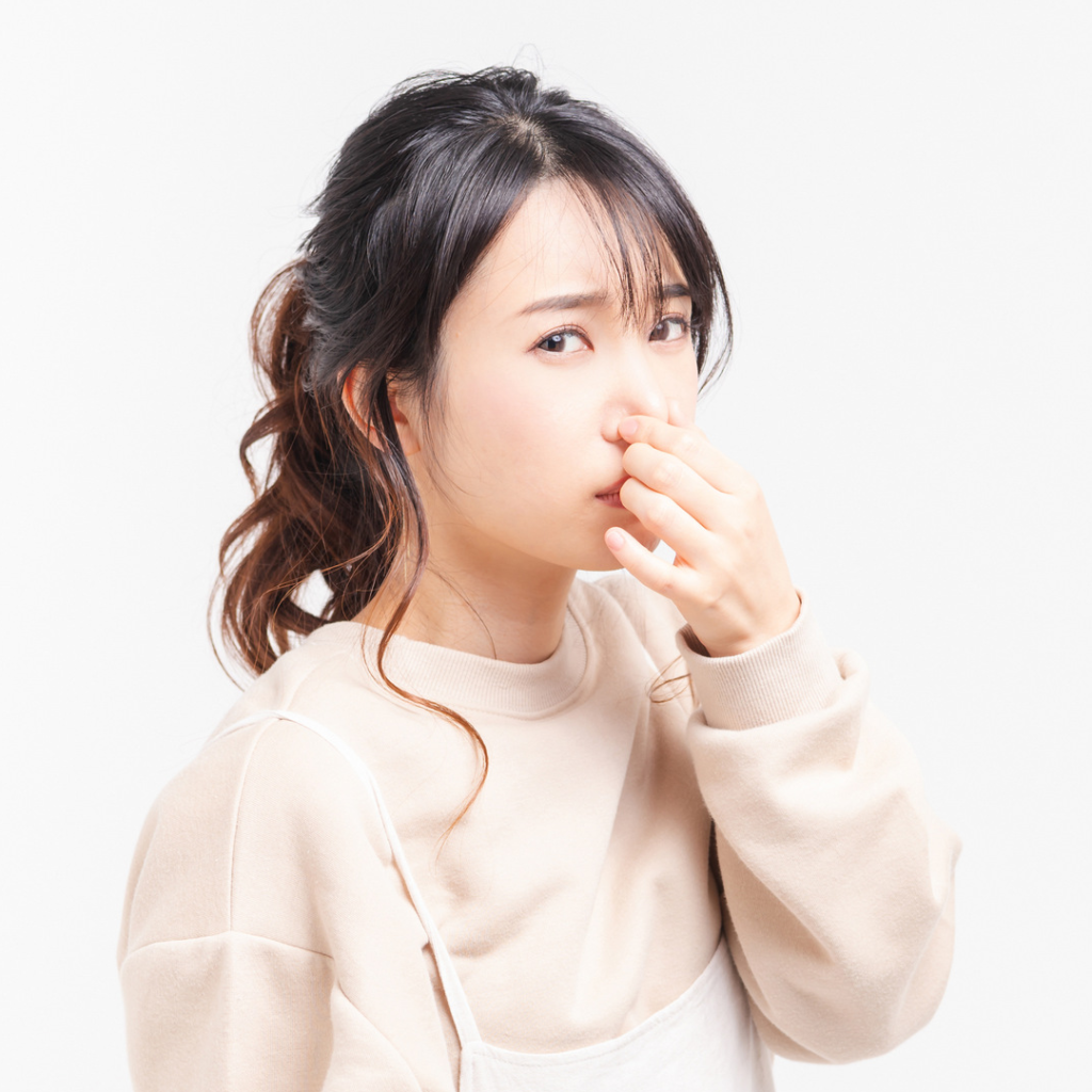 鼻を摘まんでいる女性